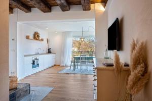 a living room with a kitchen and a dining room at Eichhof Apartment Lavendel in Termeno