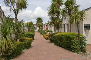 a brick walk way with palm trees and bushes at Birchwood Hotel and OR Tambo Conference Centre in Boksburg