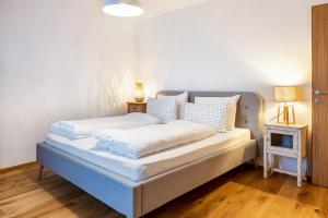 1 dormitorio con 2 camas con sábanas blancas y lámpara en Eichhof Apartment Lavendel en Termeno
