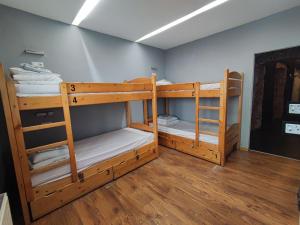 two bunk beds in a room with wooden floors at Greg&Tom Party Hostel in Krakow