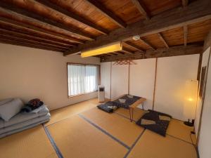 ein Wohnzimmer mit einem Sofa und einem Tisch in der Unterkunft MEKIKI古民家 in Yamanashi