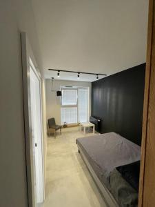 a bedroom with a bed and a black wall at Piękny i nowy apartament, z darmowym parkingiem in Łódź