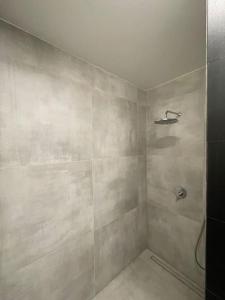 a bathroom with a shower with a tiled wall at Piękny i nowy apartament, z darmowym parkingiem in Łódź