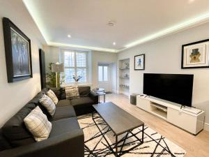 a living room with a couch and a flat screen tv at Modern 3 Bedroom Apartment, West End in Edinburgh
