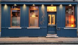 een blauwe winkel voor een gebouw met ramen bij Logies La Chèvre Folle in Oostende