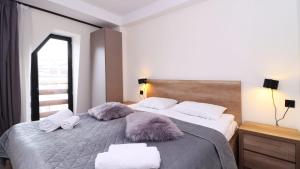 een slaapkamer met een groot bed met donzige kussens bij 2BR Apartment in Marshall Gudauri Project in Goedaoeri