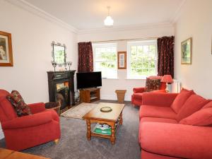 a living room with red couches and a tv at Millerbeck in Ambleside