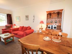 安布爾塞德的住宿－Millerbeck，客厅配有红色的沙发和桌子