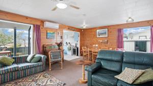 ein Wohnzimmer mit einem Sofa und einem Tisch in der Unterkunft Roseville - Snells Beach Holiday Home in Snells Beach