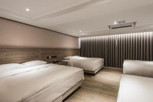 a hotel room with two beds and a wall with at Spring Rhapsody Hotel in Taichung
