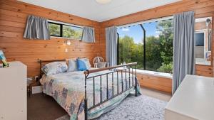 a bedroom with a bed and a window at Beachglen - Snells Beach Holiday Home in Snells Beach
