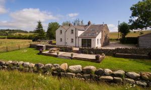 a large white house with a stone wall in front of it at Beck View in Troutbeck