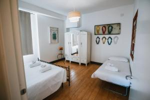 ピエトラ・リーグレにあるAgriturismo Rose di Pietraの小さな部屋で、ベッド2台、鏡が備わります。