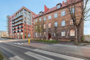 an empty street in front of a large brick building at Danzig 1925 Old Town Apartment in Gdańsk