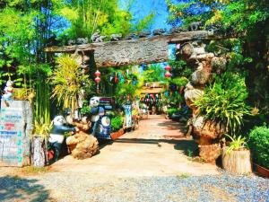 a walkway in a garden with plants and trees at Denchai City Resort เด่นชัยซิตี้ รีสอร์ท in Phrae