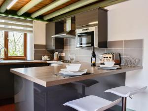 a kitchen with a counter with a bottle of wine at Darcis Lodge - Uk1297 in Threlkeld