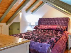 a bedroom with a purple bed in a attic at Darcis Lodge - Uk1297 in Threlkeld