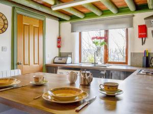 una cocina con una mesa de madera con platos. en Lucys Lodge - Uk1260, en Threlkeld