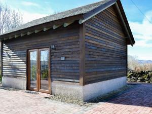 un pequeño edificio de madera con puerta en Lucys Lodge - Uk1260, en Threlkeld