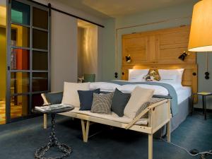 a bedroom with a bed and a couch and a table at 25hours Hotel Altes Hafenamt in Hamburg
