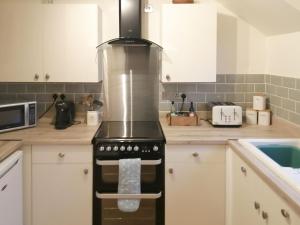 a kitchen with a stove top oven in a kitchen at Riverside View in Nairn