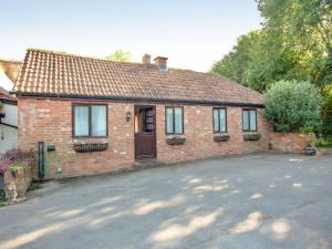 a brick house with a driveway in front of it at The Stables in Clyst Saint Mary