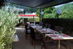 a row of tables and chairs under an umbrella at Kyriad Limoges Sud - Feytiat in Feytiat