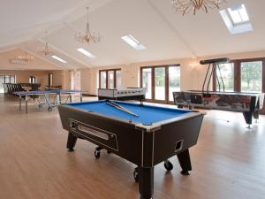 a room with a pool table and several tables at Kingfisher Barn in Sculthorpe