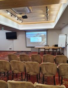 uma sala de conferências com um ecrã e cadeiras em Hotel Maria & Spa em Szczawnica