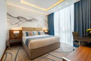Habitación de hotel con cama y ventana grande en CHARLI Hotel Jeddah en Yeda