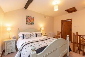1 dormitorio con 1 cama blanca grande en una habitación en Swinside Cottage, en Keswick