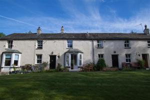 una gran casa blanca con césped delante en Swinside Cottage, en Keswick