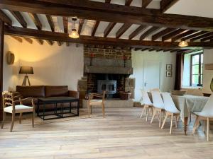 a living room with a couch and chairs and a fireplace at Maison de charme à Joué-du-Bois avec vue sur le lac in Joué-du-Bois