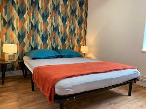 a bedroom with a bed with a colorful headboard at Maison de 4 chambres avec vue sur le lac et jardin amenage a Joue du Bois in Joué-du-Bois