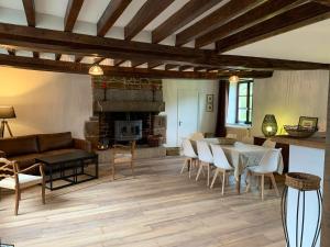 a living room with a table and chairs and a fireplace at Maison de charme à Joué-du-Bois avec vue sur le lac in Joué-du-Bois +11 photos