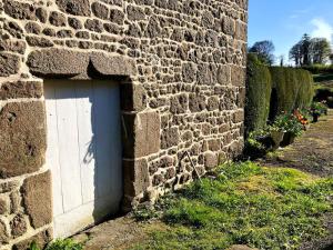 a brick wall with a white door in the corner at Maison de charme à Joué-du-Bois avec vue sur le lac in Joué-du-Bois