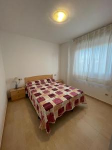 1 dormitorio con 1 cama con edredón en Alpen1 Pompeya, en Peñíscola