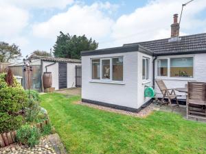 a tiny house with a patio and a table at White Cottage in Little Carlton