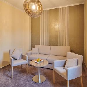ein Wohnzimmer mit einem Sofa, 2 Stühlen und einem Tisch in der Unterkunft Ambient Hotel Zum Schwan in Gelsenkirchen
