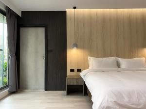 a bedroom with a large white bed and a door at Chapter 127 in Tainan