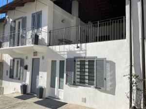 een wit gebouw met blauwe luiken en een balkon bij HomeSweetHome - Pavarolo ,TO, Italia in Pavarolo