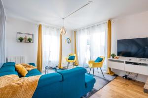 - un salon avec un canapé bleu et des chaises dans l'établissement CAOPEO - Top Hôte Paris - 8 personnes Balcon Parking, à Saint-Denis