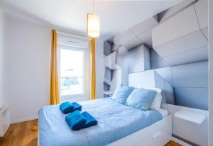 a bedroom with a blue bed with blue pillows at CAOPEO - Top Hôte Paris - 8 personnes Balcon Parking in Saint-Denis