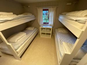 3 Etagenbetten in einem Zimmer mit Fenster in der Unterkunft Lullens Stugby - Stugorna 1-5 in Bruksvallarna