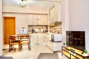 uma cozinha com uma mesa e uma sala de jantar em Apartment Viewing Garden em Volos
