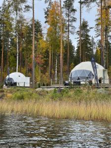 twee tenten op een dok naast een waterlichaam bij Maja Luxury Glamping Suites in Mäntyharju