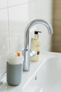 a kitchen sink with a faucet and a cup on a counter at Wohnen auf Zeit in Weingarten in Weingarten +75 photos