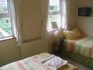 ニューキーにあるPriory Lodge Hotelのベッドが2つと窓が2つある寝室 +6枚の写真