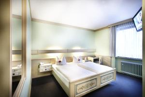 a bedroom with a large white bed with a window at Hotel Hannover Airport by Premiere Classe in Hannover