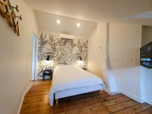 een slaapkamer met een bed en een muurschildering bij Appartement Premium dans une belle demeure - Hyper centre-ville de Reims in Reims